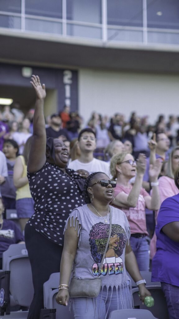 Crowd worshiping with raised hands at an outdoor event