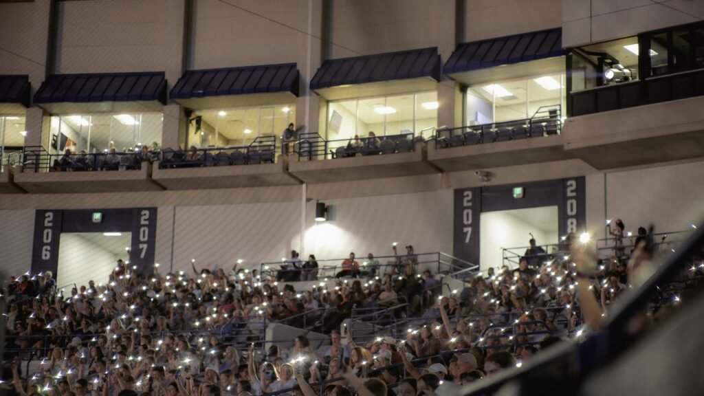 Stadium crowd holding up phone lights at night