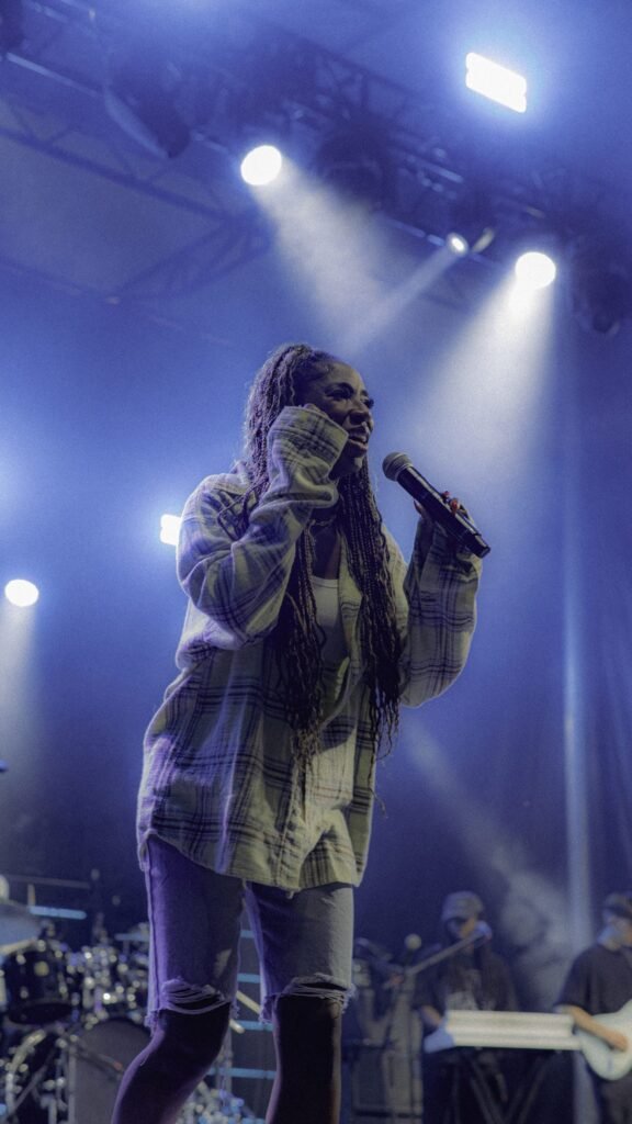 Female vocalist singing with eyes closed under blue stage light